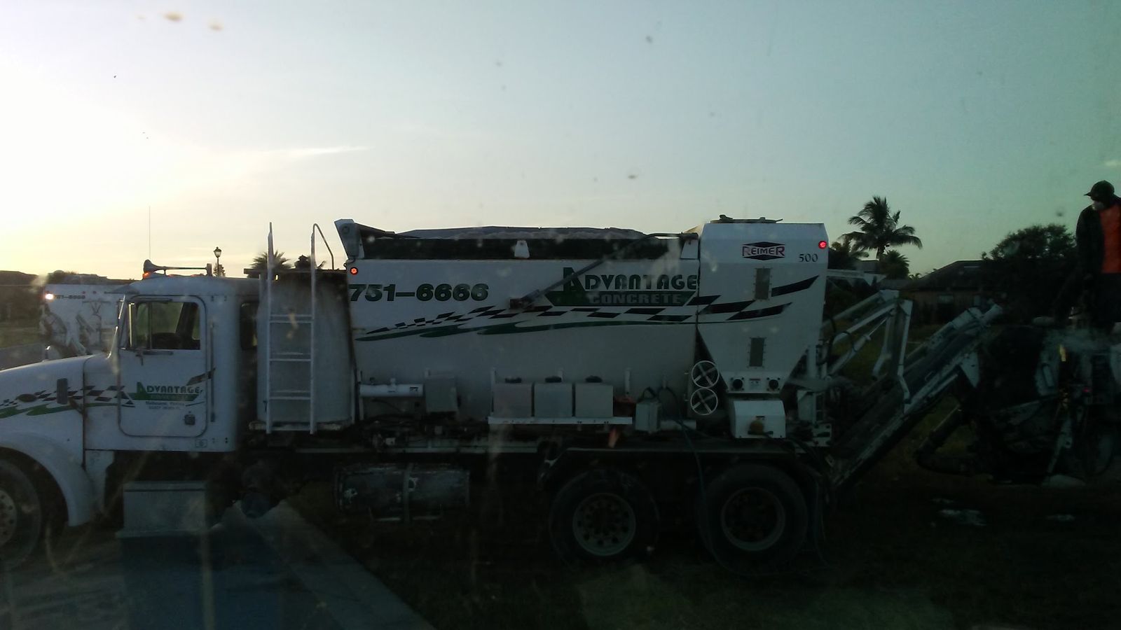 Advantage Concrete mixer truck at dusk, seen from the side with its chute swung out